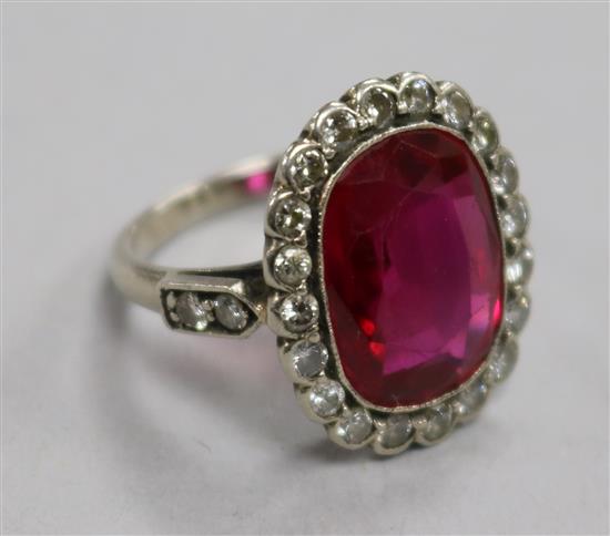 A mid 20th century platinum?, synthetic ruby and diamond set oval dress ring, size I.
